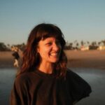 Therapist Danielle Wiggins smiling with long dark hair wearing a dark top in nature.