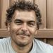 Couples Analytics Founder Brian Calley with curly dark brown hair smiling and wearing a light gray shirt.