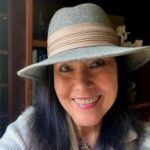 CHRISTINE BAUMGARTNER
Expert Dating and Relationship Coach at The Perfect Catch smiling and wearing a light blue hat and top.