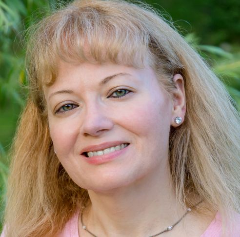 Michelle Troutman smiling warmly with long ash blonde hair.